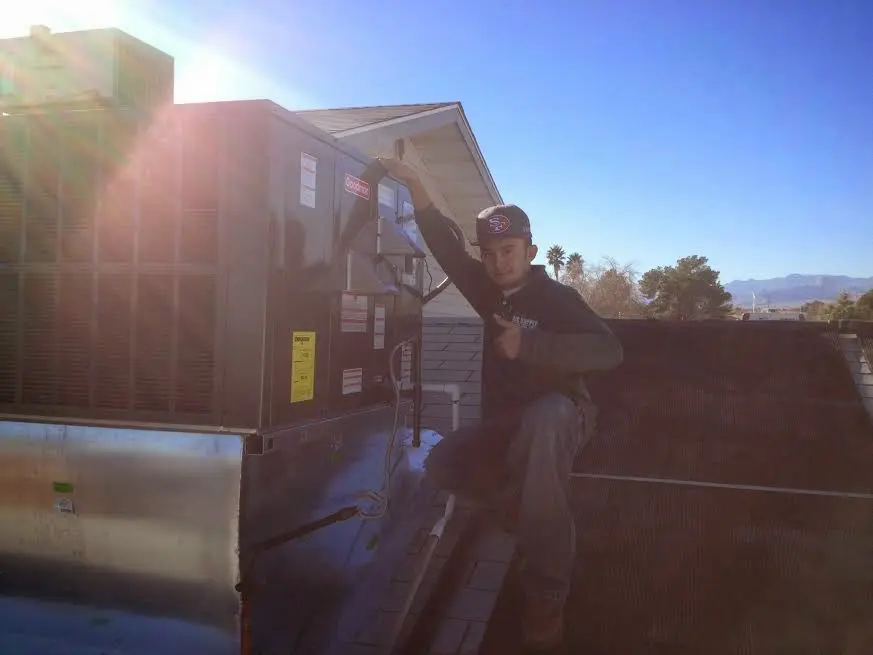 HVAC technician performing HVAC Inspection on a rooftop unit in Porter